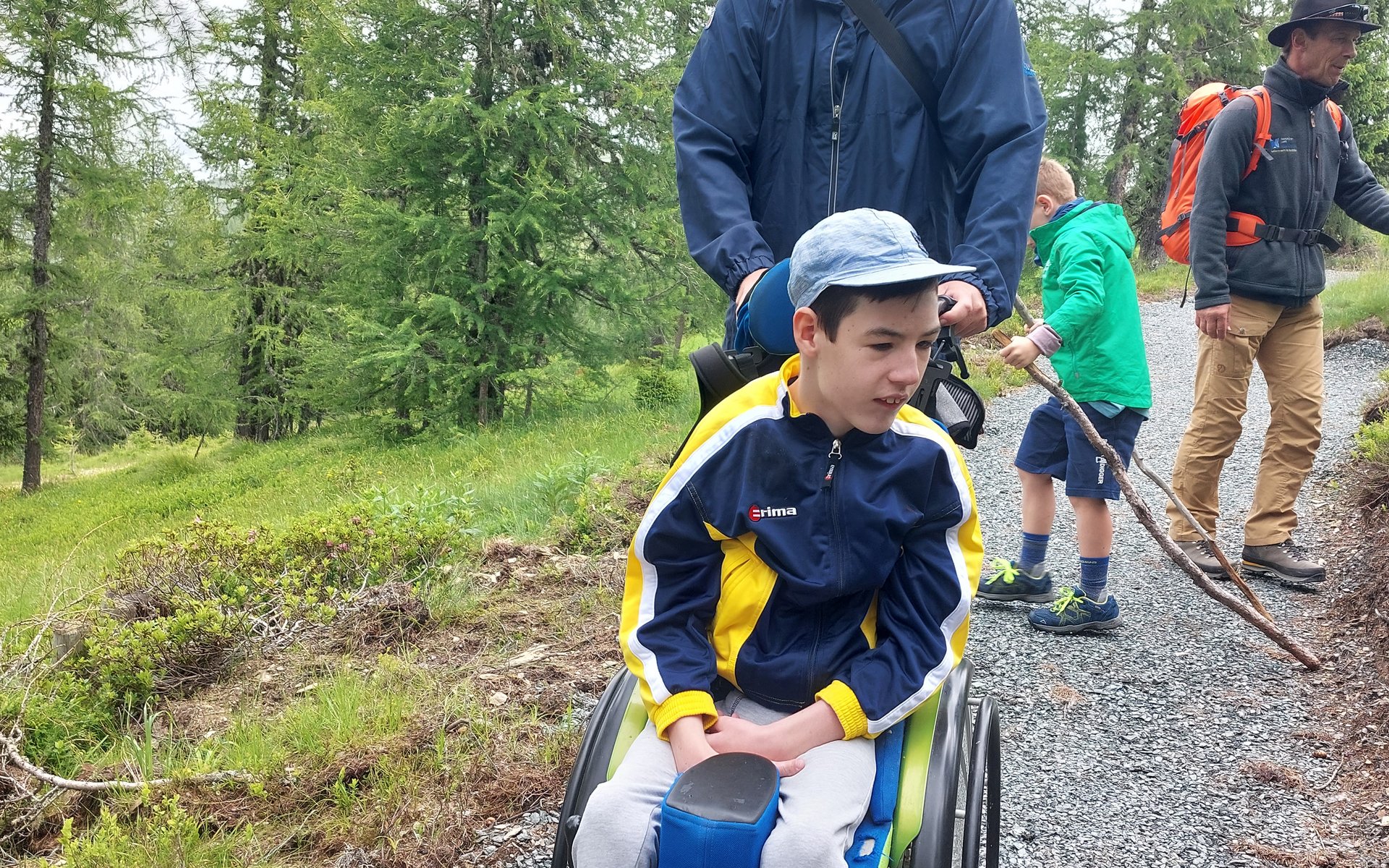 Vater und Sohn im Rollstuhl am Wanderweg